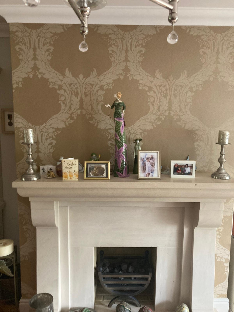 Wallpapering around a fireplace in a Dublin sitting room by Abhaile Decorators, Ireland